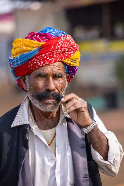 Puşkar, Rajasthan, Hindistan - 25 Kasım 2023: Puşkar Fuarı, Rajasthani 'li yaşlı bir erkeğin portresi geleneksel elbise ve renkli türbanlı bir adam.
