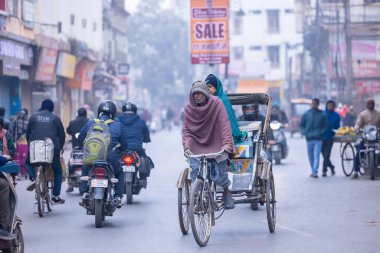 Varanasi, Uttar Pradesh, Hindistan - 05 Mart 2023: Varanasi 'deki çetelerin yakınındaki ghatlarda geleneksel giysiler giyen insanlar.