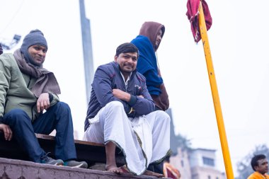 Varanasi, Uttar Pradesh, Hindistan - 05 Mart 2023: Varanasi 'deki çetelerin yakınındaki ghatlarda geleneksel giysiler giyen insanlar.