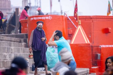 Varanasi, Uttar Pradesh, Hindistan - 05 Mart 2023: Varanasi 'deki çetelerin yakınındaki ghatlarda geleneksel giysiler giyen insanlar.