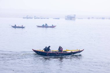 Varanasi, Uttar Pradesh, Hindistan - 05 Mart 2023: Varanasi 'deki çetelerin yakınındaki ghatlarda geleneksel giysiler giyen insanlar.
