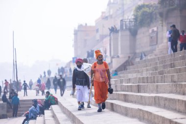 Varanasi, Uttar Pradesh, Hindistan - 19 Ocak 2024: Varanasi 'deki kutsal nehir gangası ghatlarındaki insanlar.