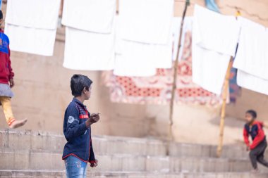 Varanasi, Uttar Pradesh, Hindistan - 19 Ocak 2024: Varanasi 'deki kutsal nehir gangası ghatlarındaki insanlar.