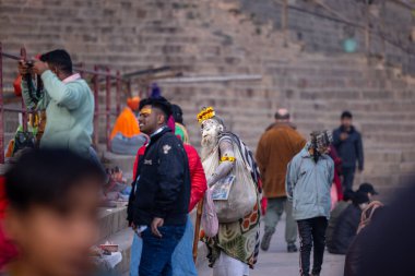 Varanasi, Uttar Pradesh, Hindistan - 18 Ocak 2024: Varanasi 'deki çetelerin yakınındaki ghat' larda yaşayan insanlar. Sadhu, Kaşhi 'de Ganga yakınlarında meditasyon yapıyor..