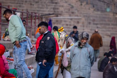 Varanasi, Uttar Pradesh, Hindistan - 18 Ocak 2024: Varanasi 'deki çetelerin yakınındaki ghat' larda yaşayan insanlar. Sadhu, Kaşhi 'de Ganga yakınlarında meditasyon yapıyor..