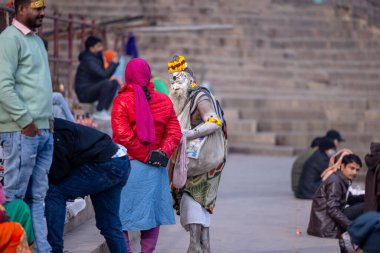 Varanasi, Uttar Pradesh, Hindistan - 18 Ocak 2024: Varanasi 'deki çetelerin yakınındaki ghat' larda yaşayan insanlar. Sadhu, Kaşhi 'de Ganga yakınlarında meditasyon yapıyor..