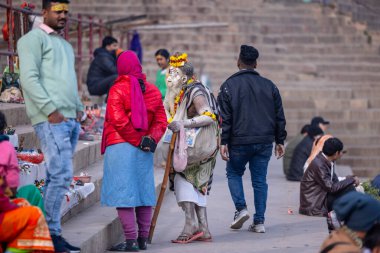 Varanasi, Uttar Pradesh, Hindistan - 18 Ocak 2024: Varanasi 'deki çetelerin yakınındaki ghat' larda yaşayan insanlar. Sadhu, Kaşhi 'de Ganga yakınlarında meditasyon yapıyor..