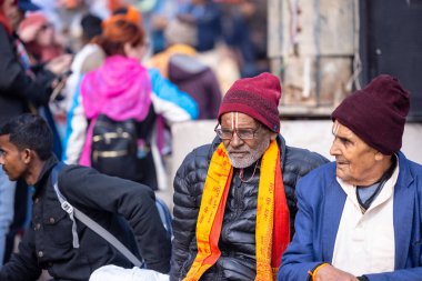 Varanasi, Uttar Pradesh, Hindistan - 05 Mart 2023: Varanasi 'deki çetelerin yakınındaki ghatlarda geleneksel giysiler giyen insanlar.