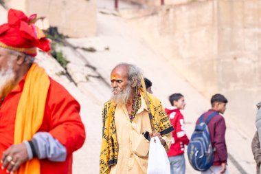 Varanasi, Uttar Pradesh, Hindistan - 19 Ocak 2024: Varanasi 'deki çetelerin yakınındaki ghatlarda geleneksel giysili insanlar