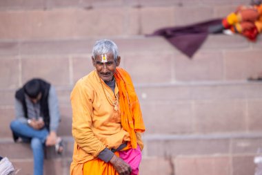 Varanasi, Uttar Pradesh, Hindistan - 19 Ocak 2024: Varanasi 'deki çetelerin yakınındaki ghatlarda geleneksel giysili insanlar