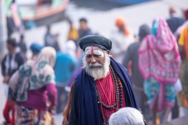 Varanasi, Uttar Pradesh, Hindistan - 19 Ocak 2024: Varanasi 'deki çetelerin yakınındaki ghatlarda geleneksel giysili insanlar
