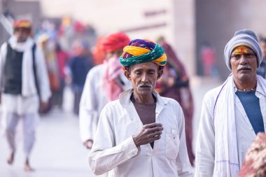 Varanasi, Uttar Pradesh, Hindistan - 19 Ocak 2024: Varanasi 'deki çetelerin yakınındaki ghatlarda geleneksel giysili insanlar