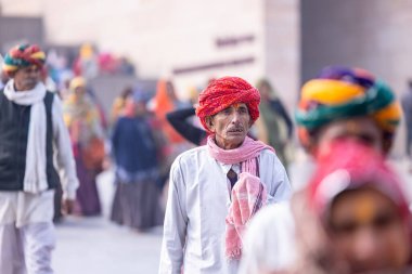 Varanasi, Uttar Pradesh, Hindistan - 19 Ocak 2024: Varanasi 'deki çetelerin yakınındaki ghatlarda geleneksel giysili insanlar