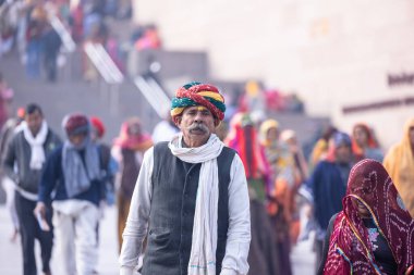 Varanasi, Uttar Pradesh, Hindistan - 19 Ocak 2024: Varanasi 'deki çetelerin yakınındaki ghatlarda geleneksel giysili insanlar