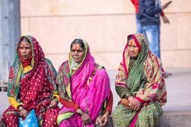 Varanasi, Uttar Pradesh, Hindistan - 19 Ocak 2024: Maharashtra 'lı Hintli kadınlar grubu Varanasi' deki gnaga nehri yakınlarındaki ghatlarda geleneksel saride oturuyorlar.