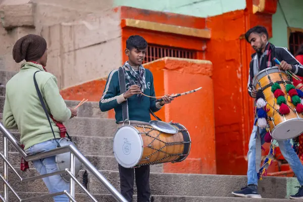 Varanasi, Uttar Pradesh, Hindistan - 05 Mart 2023: Varanasi 'deki çetelerin yakınındaki ghatlarda geleneksel giysiler giyen insanlar.