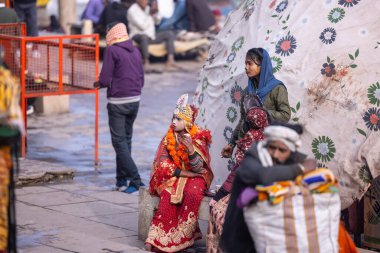 Varanasi, Uttar Pradesh, Hindistan - 19 Ocak 2024: Varanasi 'deki çetelerin yakınındaki ghatlarda geleneksel giysili insanlar