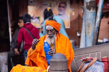 Varanasi, Uttar Pradesh, Hindistan - 19 Ocak 2024: Varanasi 'deki çetelerin yakınındaki ghatlarda geleneksel giysili insanlar