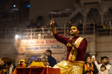 Varanasi, Uttar Pradesh, India - January 19 2024: Ganga aarti at dashashwamedh ghat in traditional dress with hindu rituals. clipart