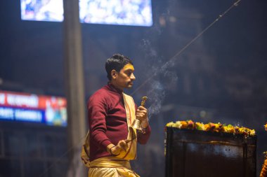 Varanasi, Uttar Pradesh, India - January 19 2024: Ganga aarti at dashashwamedh ghat in traditional dress with hindu rituals. clipart