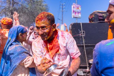 İnsanlar geleneksel ve törensel renkli Lathmar Holi 'yi Radharani tapınağında dans ve renkli yüzlerle kutluyorlar.