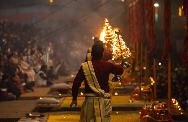 Varanasi, Uttar Pradesh, India: Ganga aarti, priest performing holy river ganges evening aarti at dashashwamedh ghat in traditional dress with hindu rituals. clipart