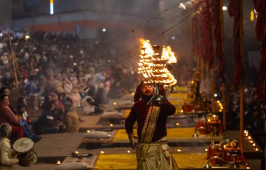 Varanasi, Uttar Pradesh, India: Ganga aarti, priest performing holy river ganges evening aarti at dashashwamedh ghat in traditional dress with hindu rituals. clipart