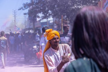 People celebrate the traditional and a ritualistic colorful Lathmar Holi with dance and colored faces at Radharani temple clipart