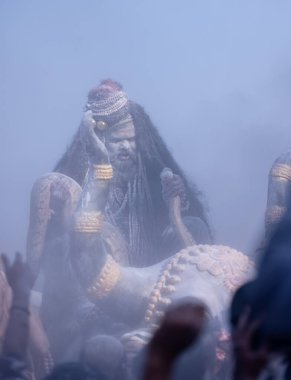 Varanasi, Uttar Pradesh, Hindistan - Mart 03 2023: Masan Holi, Harishchandra Ghat 'taki masaan Holi kutlamaları sırasında Lord Shiva gibi giyinmiş kül yüzlü bir erkek dindar portresi.