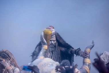 Varanasi, Uttar Pradesh, Hindistan - Mart 03 2023: Masan Holi, Harishchandra Ghat 'taki masaan Holi kutlamaları sırasında Lord Shiva gibi giyinmiş kül yüzlü bir erkek dindar portresi.