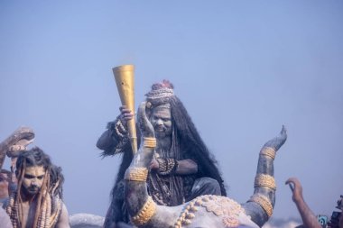 Varanasi, Uttar Pradesh, Hindistan - Mart 03 2023: Masan Holi, Harishchandra Ghat 'taki masaan Holi kutlamaları sırasında Lord Shiva gibi giyinmiş kül yüzlü bir erkek dindar portresi.