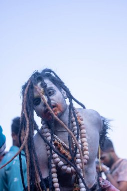 Varanasi, Uttar Pradesh, Hindistan - Mart 03 2023: Masan Holi, Harishchandra Ghat 'taki masaan Holi kutlamaları sırasında Lord Shiva gibi giyinmiş kül yüzlü bir erkek dindar portresi.