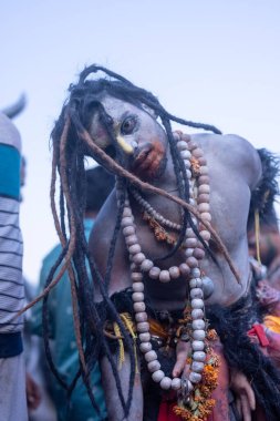 Varanasi, Uttar Pradesh, Hindistan - Mart 03 2023: Masan Holi, Harishchandra Ghat 'taki masaan Holi kutlamaları sırasında Lord Shiva gibi giyinmiş kül yüzlü bir erkek dindar portresi.