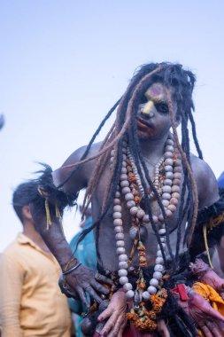 Varanasi, Uttar Pradesh, Hindistan - Mart 03 2023: Masan Holi, Harishchandra Ghat 'taki masaan Holi kutlamaları sırasında Lord Shiva gibi giyinmiş kül yüzlü bir erkek dindar portresi.