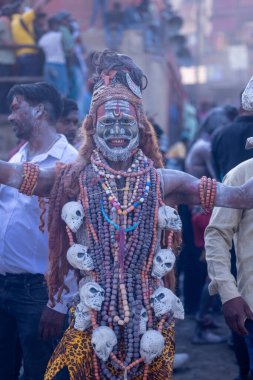 Varanasi, Uttar Pradesh, Hindistan - Mart 03 2023: Masan Holi, Harishchandra Ghat 'taki masaan Holi kutlamaları sırasında Lord Shiva gibi giyinmiş kül yüzlü bir erkek dindar portresi.