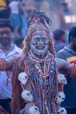 Varanasi, Uttar Pradesh, Hindistan - Mart 03 2023: Masan Holi, Harishchandra Ghat 'taki masaan Holi kutlamaları sırasında Lord Shiva gibi giyinmiş kül yüzlü bir erkek dindar portresi.