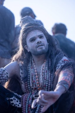 Varanasi, Uttar Pradesh, Hindistan - Mart 03 2023: Masan Holi, Harishchandra Ghat 'taki masaan Holi kutlamaları sırasında Lord Shiva gibi giyinmiş kül yüzlü bir erkek dindar portresi.