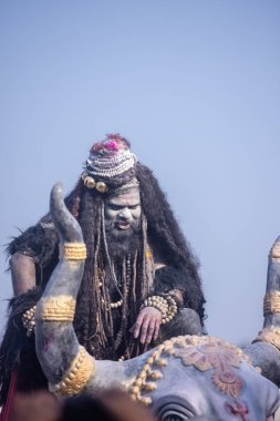 Varanasi, Uttar Pradesh, Hindistan - Mart 03 2023: Masan Holi, Harishchandra Ghat 'taki masaan Holi kutlamaları sırasında Lord Shiva gibi giyinmiş kül yüzlü bir erkek dindar portresi.