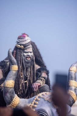 Varanasi, Uttar Pradesh, Hindistan - Mart 03 2023: Masan Holi, Harishchandra Ghat 'taki masaan Holi kutlamaları sırasında Lord Shiva gibi giyinmiş kül yüzlü bir erkek dindar portresi.