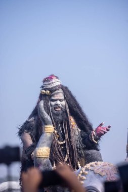 Varanasi, Uttar Pradesh, Hindistan - Mart 03 2023: Masan Holi, Harishchandra Ghat 'taki masaan Holi kutlamaları sırasında Lord Shiva gibi giyinmiş kül yüzlü bir erkek dindar portresi.