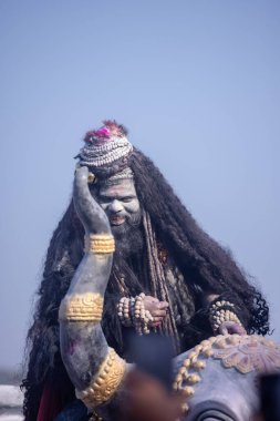 Varanasi, Uttar Pradesh, Hindistan - Mart 03 2023: Masan Holi, Harishchandra Ghat 'taki masaan Holi kutlamaları sırasında Lord Shiva gibi giyinmiş kül yüzlü bir erkek dindar portresi.