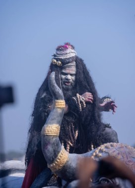 Varanasi, Uttar Pradesh, Hindistan - Mart 03 2023: Masan Holi, Harishchandra Ghat 'taki masaan Holi kutlamaları sırasında Lord Shiva gibi giyinmiş kül yüzlü bir erkek dindar portresi.