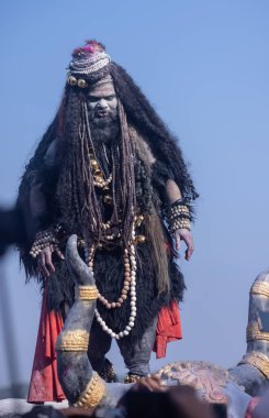 Varanasi, Uttar Pradesh, Hindistan - Mart 03 2023: Masan Holi, Harishchandra Ghat 'taki masaan Holi kutlamaları sırasında Lord Shiva gibi giyinmiş kül yüzlü bir erkek dindar portresi.