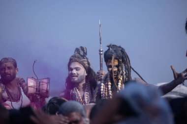 Varanasi, Uttar Pradesh, Hindistan - Mart 03 2023: Masan Holi, Harishchandra Ghat 'taki masaan Holi kutlamaları sırasında Lord Shiva gibi giyinmiş kül yüzlü bir erkek dindar portresi.
