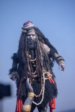 Varanasi, Uttar Pradesh, Hindistan - Mart 03 2023: Masan Holi, Harishchandra Ghat 'taki masaan Holi kutlamaları sırasında Lord Shiva gibi giyinmiş kül yüzlü bir erkek dindar portresi.