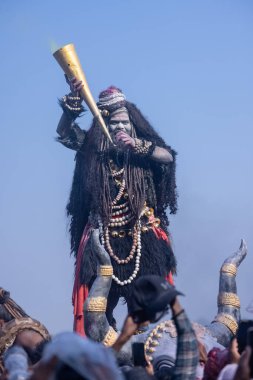 Varanasi, Uttar Pradesh, Hindistan - Mart 03 2023: Masan Holi, Harishchandra Ghat 'taki masaan Holi kutlamaları sırasında Lord Shiva gibi giyinmiş kül yüzlü bir erkek dindar portresi.