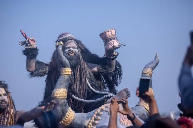 Varanasi, Uttar Pradesh, Hindistan - Mart 03 2023: Masan Holi, Harishchandra Ghat 'taki masaan Holi kutlamaları sırasında Lord Shiva gibi giyinmiş kül yüzlü bir erkek dindar portresi.