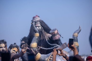 Varanasi, Uttar Pradesh, Hindistan - Mart 03 2023: Masan Holi, Harishchandra Ghat 'taki masaan Holi kutlamaları sırasında Lord Shiva gibi giyinmiş kül yüzlü bir erkek dindar portresi.