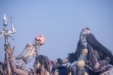 Varanasi, Uttar Pradesh, Hindistan - Mart 03 2023: Masan Holi, Harishchandra Ghat 'taki masaan Holi kutlamaları sırasında Lord Shiva gibi giyinmiş kül yüzlü bir erkek dindar portresi.
