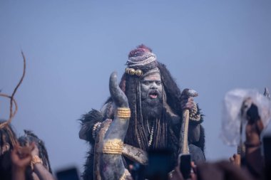 Varanasi, Uttar Pradesh, Hindistan - Mart 03 2023: Masan Holi, Harishchandra Ghat 'taki masaan Holi kutlamaları sırasında Lord Shiva gibi giyinmiş kül yüzlü bir erkek dindar portresi.